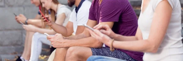 A group of people sitting on a bench Description automatically generated